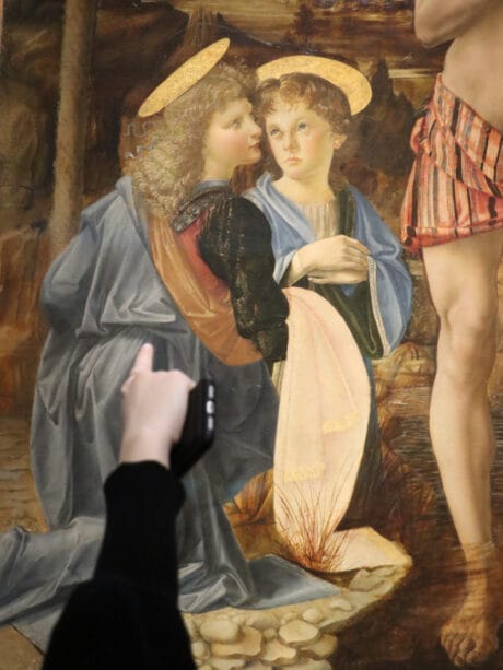 Baptism of Christ Angel Detail pointed out by a hand with a phone