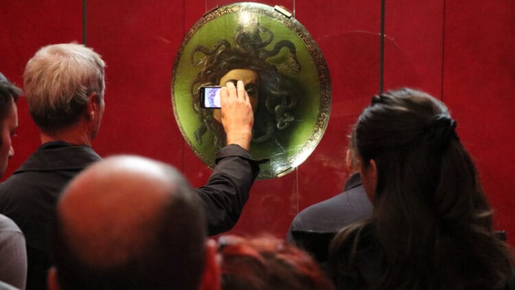 Caravaggio's Medusa in the Uffizi Gallery in Florence with phone camera in the way
